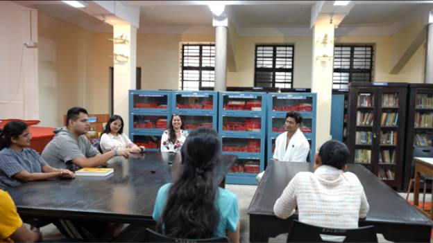 In discussion with students and faculty in the college library